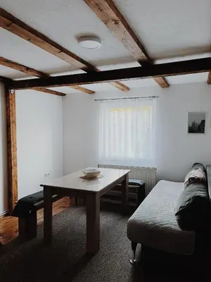 a living room with a table and a couch at Vikendica Eden in Vlasic