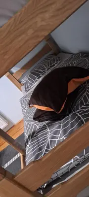 a bunk bed with black and white sheets and pillows at Apartman Jonjić in Kupres
