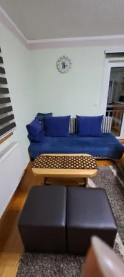 a living room with a blue couch and a table at Apartman Jonjić in Kupres