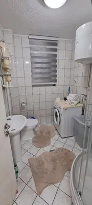 a bathroom with a toilet sink and a washing machine at Apartman Jonjić in Kupres