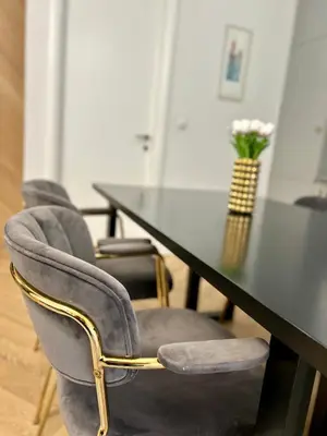 a table with four chairs and a table with a vase of flowers at Apartman Venecija Banja Luka in Banja Luka