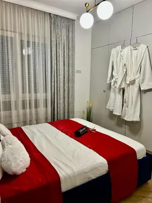 a bedroom with a bed with a red and white blanket at Apartman Venecija Banja Luka in Banja Luka