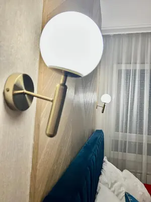 a lamp in a room with a blue couch at Apartman Venecija Banja Luka in Banja Luka