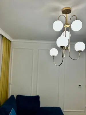 a chandelier in a living room with a blue couch at Apartman Venecija Banja Luka in Banja Luka