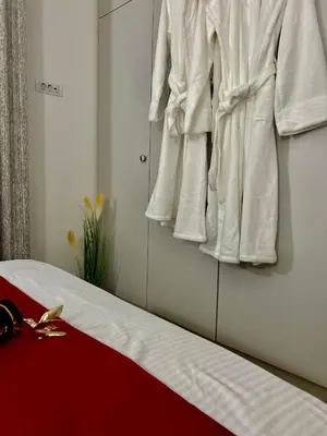 a bedroom with white clothes hanging on a wall at Apartman Venecija Banja Luka in Banja Luka