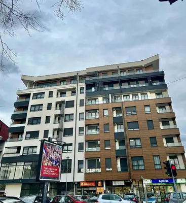 a large building with cars parked in front of it at Apartman Venecija Banja Luka in Banja Luka