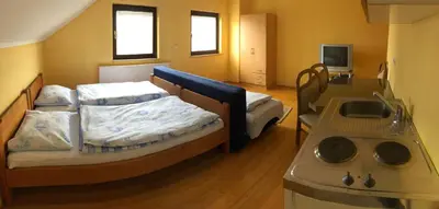 a small room with two beds and a stove at Apartmani Turalija in Kupres