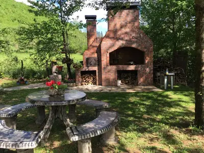 a picnic table and a brick fireplace in a yard at GOLD RIVER in Krupa na Vrbasu