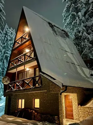 a house with snow on the roof of it at KUĆA NENO in Vlasic