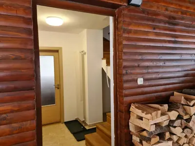 a room with a wooden wall and a pile of wood at KUĆA NENO in Vlasic