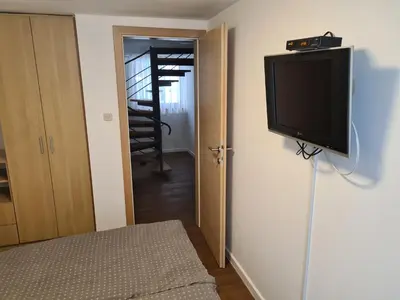 a flat screen tv on a wall in a room at KUĆA NENO in Vlasic