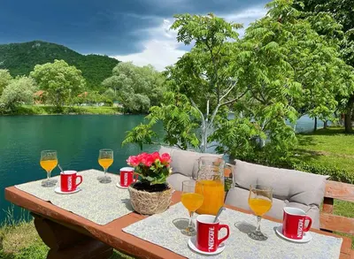 a picnic table with wine glasses and flowers on it at Crystal Račić in Bihać