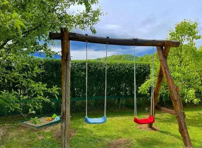a swing set in a yard with a hedge at Crystal Račić in Bihać