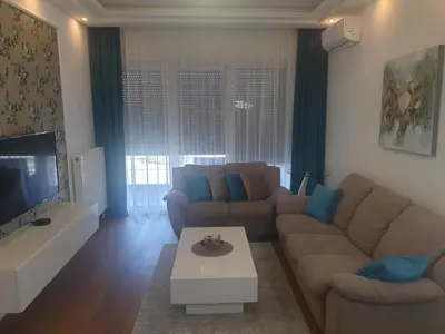 a living room with a couch and a tv at City Center Apartment in Banja Luka