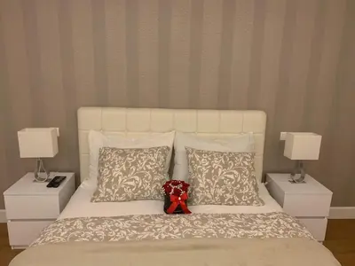 a teddy bear sitting on a bed with pillows at City Center Apartment in Banja Luka