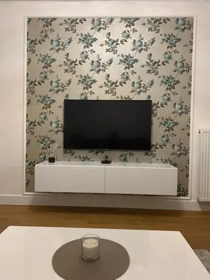 a living room with a flat screen tv on a wall at City Center Apartment in Banja Luka