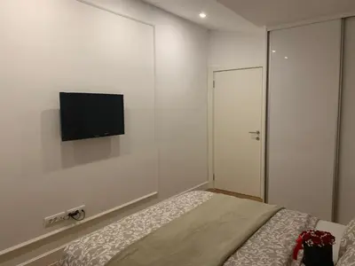 a bedroom with a bed and a flat screen tv on the wall at City Center Apartment in Banja Luka