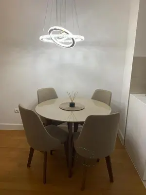 a dining room with a table and four chairs at City Center Apartment in Banja Luka