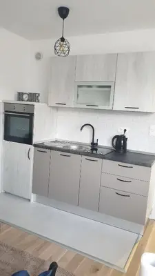 a kitchen with white cabinets and a sink at Apartman Viktoria in Tuzla