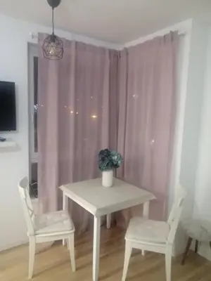 a table with two chairs and a table with a vase on it at Apartman Viktoria in Tuzla