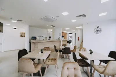 a restaurant with tables and chairs and a kitchen at Hotel Tanja in Banja Luka