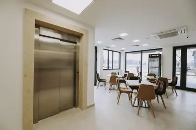 a dining room with tables and chairs and a sliding door at Hotel Tanja in Banja Luka