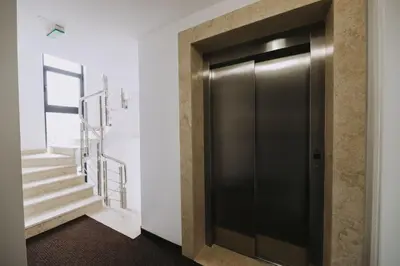 a black elevator door in a room with stairs at Hotel Tanja in Banja Luka