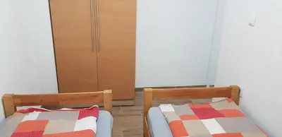 a bedroom with two beds and a closet at Apartman za dvoje in Vlasic