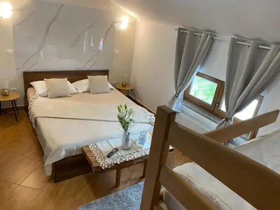 a small bedroom with a bed and a table at Hostel Mornar in Velika Kladuša