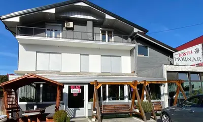 a white building with a black roof at Hostel Mornar in Velika Kladuša