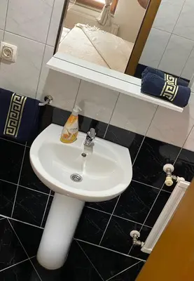 a bathroom with a white sink and a mirror at Hostel Mornar in Velika Kladuša