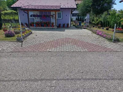 a house with a brick walkway in front of a building at SubotićSmještaj in Kulaši