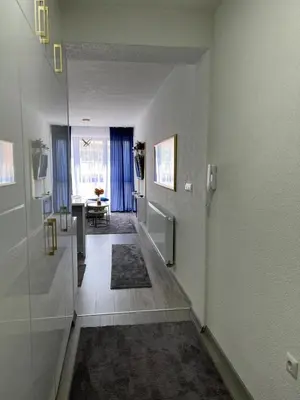 a hallway with blue curtains and a living room at Apartment Nostra Aula in Travnik