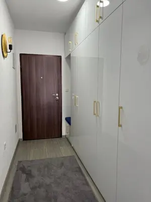 a hallway with white cabinets and a wooden door at Apartment Nostra Aula in Travnik