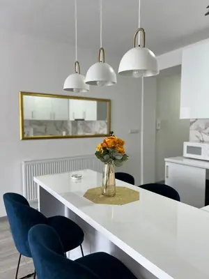 a white kitchen with a vase of flowers on a table at Apartment Nostra Aula in Travnik