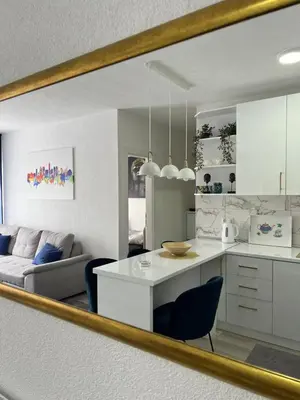 a mirror reflecting a kitchen and a living room at Apartment Nostra Aula in Travnik