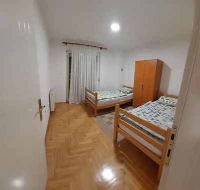 two beds in a room with wooden floors at Aleksandar in Banja Luka