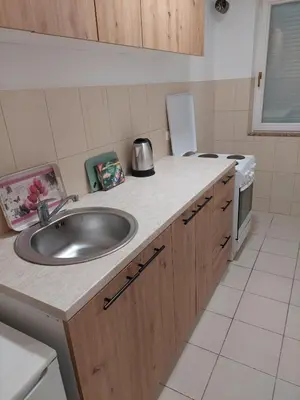 a kitchen counter with a sink and a refrigerator at Aleksandar in Banja Luka