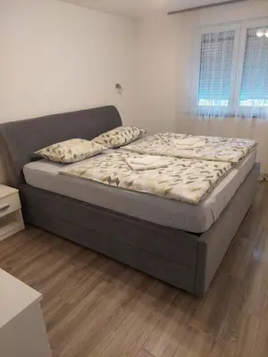 a large bed in a room with a wooden floor at Aleksandar in Banja Luka