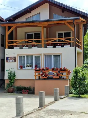 a house with flowers on the balconies at Studio Apartman SAJRA in Kulen Vakuf