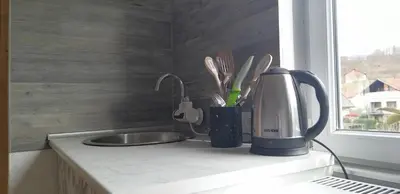 a kitchen counter with a coffee maker and a sink at Studio Apartman SAJRA in Kulen Vakuf