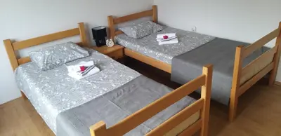 two beds in a small room with towels on them at Studio Apartman SAJRA in Kulen Vakuf