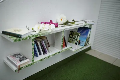 a shelf with books and flowers on top of it at Penthouse Park in Banja Luka