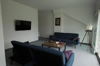 a living room with two blue couches and a table at Penthouse Park in Banja Luka