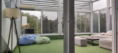 a living room with a couch and a room with windows at Penthouse Park in Banja Luka