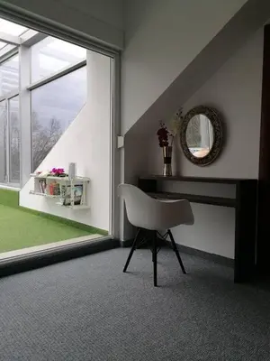 a room with a chair and a mirror and a window at Penthouse Park in Banja Luka