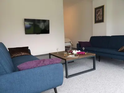 a living room with two blue couches and a coffee table at Penthouse Park in Banja Luka