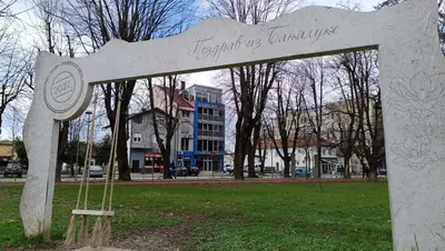 a monument in a park with a building in the background at Penthouse Park in Banja Luka