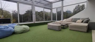 a living room with a couch and chairs and windows at Penthouse Park in Banja Luka