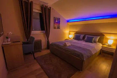 a bedroom with a bed and a blue light at Gradiska na Savi apartmani i sobe in Bosanska Gradiška